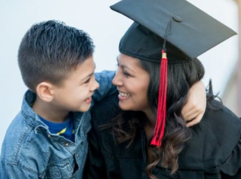 Mother in graduation cap and gown hugging her son